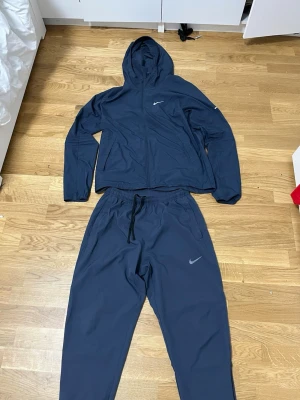 Mörkblå Nike miller tracksuit  - Snyggt mörkblått träningsset från Nike med matchande hoodie och byxor. hela travksuiten är storlek S den är ny inga problem inga skador eller något sånt använd max 3 gånger köpt från jd för ett tag sen tar byten och pris kan diskuteras 