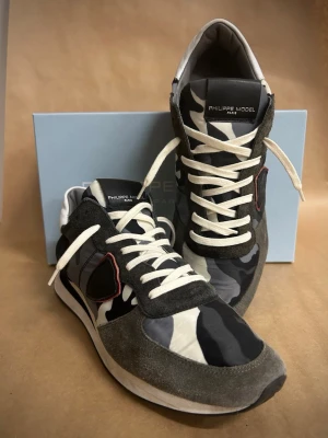 Philippe Model TRPX Camo - Philippe Model TRPX Camo – nästan nya – storlek 42  Säljer ett par riktigt snygga Philippe Model TRPX Camo i storlek 42.  Svart/grå camo med mörka detaljer – stilrena och lätta att matcha till det mesta.  ✔ Storlek: 42 ✔ Skick: Nästan nya (väldigt lite använda) ✔ Nypris: 4000 kr ✔ Pris: 1249 kr  Säljer dem då de inte kommer till användning.  📩 Hör av dig vid intresse! 