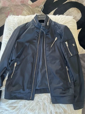 Svart bomberjacka från Tiger of Sweden - Snygg mörkblå jacka från rock and blue. Passar bra till våren, sena sommarkvällar och även hösten. Den är i mycket bra skick inte inte använd den ofta 