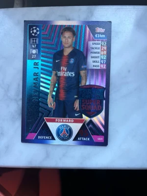 Neymar JR limited Edition PSG champions league - Samlarkort från Topps Match Attax med Paris Saint-Germain Forward. Kortet har en holografisk yta och visar statistik som speed, skill och shoot. Färgerna är blå, röd och silver med PSG-logga och UEFA Champions League-märke.