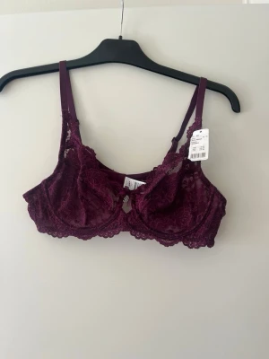 Vinröd spets-bh från Cubus - Säljer en vinröd bh från Cubus i modellen Bella. Bh:n är i vacker spets med justerbara axelband och bygel för extra stöd. Perfekt för dig som gillar en feminin och elegant stil.