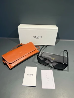 Svarta solglasögon från Celine - Kommer med originalbox, läderfodral, putsduk och äkthetskort. Mycket sparsamt använda och utan synliga repor. Elegant och tidlös modell med guldfärgad Triomphe-logo på sidorna. Toppskick och riktigt exklusiv känsla.