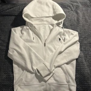 Polo Ralph lauren zip Hoodie  - Vit polo Hoodie som säljs på grund av storleken. Väldigt bra skick, Använd ett fåtal gånger. Väldigt fräsch till en clean outfit. Pris kan diskuteras!!😊