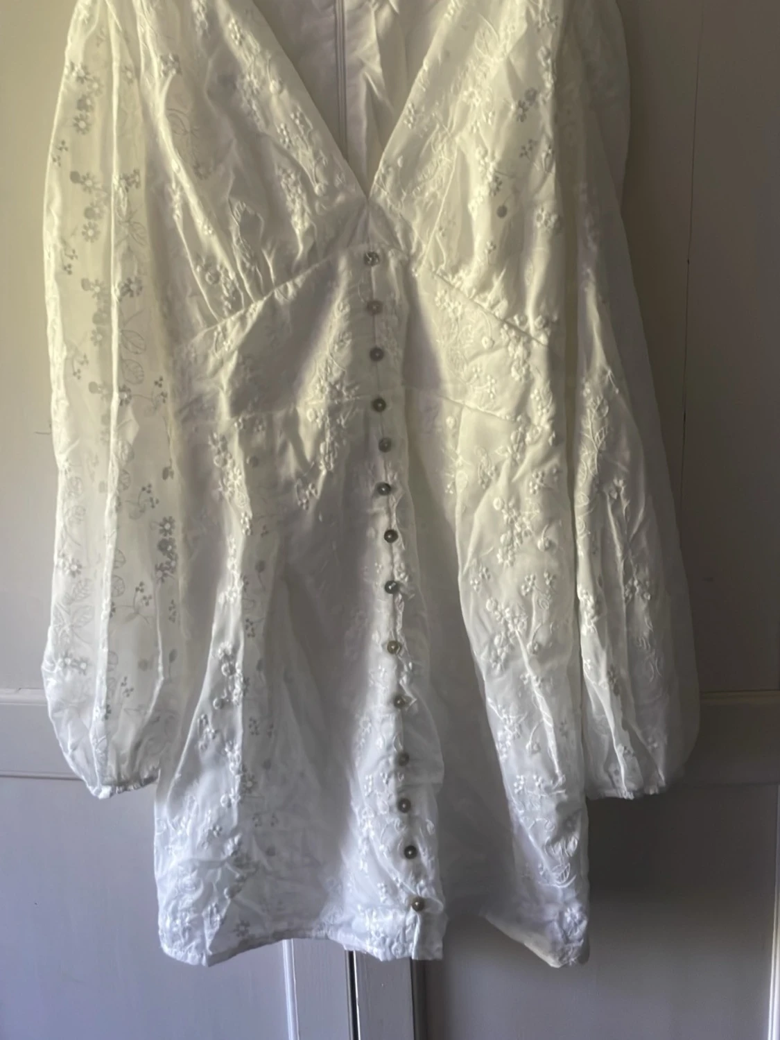 Vit broderad kortklänning med knappar och lång puffärm. Stl M - 1