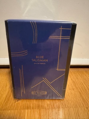 Ex Nihilo Blue Talisman EdP 100ml - Blue Talisman Eau de Parfum från Ex Nihilo i en elegant blå förpackning med guldiga detaljer. Flaskan rymmer 100 ml och doften är exklusiv och lyxig, tillverkad i Frankrike. Perfekt för dig som gillar unika och sofistikerade parfymer.