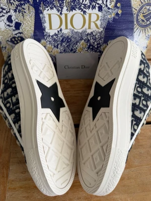 Dior dam sneakers - storlek 38 - Skolåda och allt du ser på bilderna ingår. Storlek 38 normal 38, kvitto finns, jätte jätte bra skick. Skorna är i princip nya inga tecken på användning alls. Dior sneakers💕