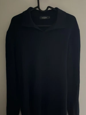 Svart tröja med krage från Dressmann - Klassisk svart långärmad tröja från Dressmann med snygg krage. Perfekt för en stilren look och enkel att matcha med olika outfits. Tillverkad i mjukt material som känns skönt mot huden.