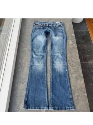 Låtmidjade jeans  - Säljer mina favorit jeans då de inte passar längre. Jätte snygga lågmidjade bootcut jeans, enda defekten är små slitningar längst ner på benen.   Midjemåttet tvärs över är 38 cm, midjehöjd 17 cm och innerbenslängd 82 cm   Skriv om ni har några frågor 🥰🥰