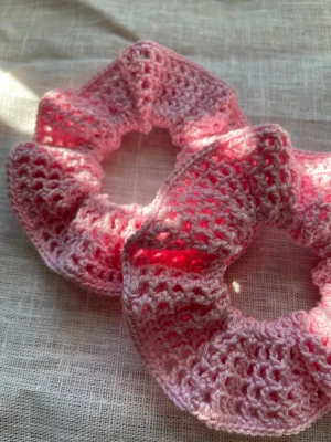 Handgjorda scrunchies virkade 100% bomull - Handgjorda scrunchies i härlig rosa nyans. Luftig, spetsliknande struktur. Set om 2 stycken. Virkade i 100% bomull. Skonsamma för håret. Diameter ca 12cm. 