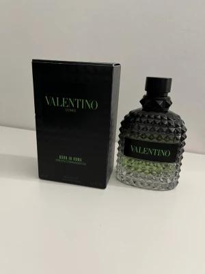Valentino Uomo Born In Roma parfym - Valentino Uomo Born In Roma Green Stravaganza är en parfym med en snygg, diamantmönstrad glasflaska i svart och grönt. Flaskan har en robust känsla och svart kork. Kommer i originalkartong med modern design och gröna detaljer.70-80ml 
