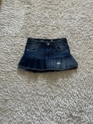 Mörkblå kjol med volang - En mörkblå jeanskjol omsydd från ett par jeans. 🌺  Midjemått tvärsöver- 35cm (stretchig)  Längd - 28cm 