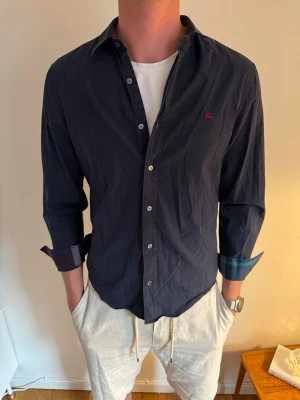 Mörkblå Burberry skjorta  - Hej! Vi säljer nu denna burberry skjortan i storlek M. Vi säljer den för endast 875kr. Skicket är riktigt bra men kan sänka priset vid snabb och smidig affär!💙 // studio II Resell 