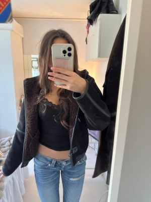 Svart skinnjacka med teddyfoder - Snygg svart skinnjacka med brunt teddyfoder och läderdetaljer. OBS! Saknas en knapp, men får med er en extra!!!💗 