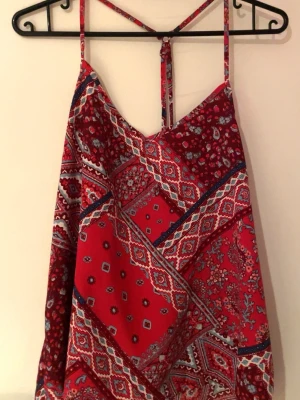 Röd linne med detaljer på  - Bra skick! Köpte den på second hand, vet tyvärr inte vart den är ifrån. 