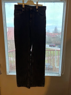 Mörkgråa  raka jeans med låg midja - Säljer ett par gråa jeans med rak passform och låg midja. Klassisk femficksmodell med knapp- och dragkedjestängning. Jeansen har en enkel och stilren look, perfekta till många olika outfits. Materialet är kraftigt denim i bomull.