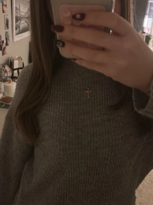 Grå ribbstickad tröja - Mysig grå ribbstickad tröja med hög hals och långa ärmar. Tröjan har en avslappnad passform och är perfekt att matcha med jeans. Materialet känns mjukt och bekvämt, perfekt för kyligare dagar.