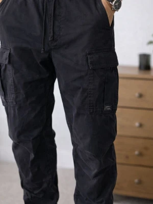 Svarta cargopants med snörning - Svarta cargopants från Smith & Soul med elastisk midja och snörning. Byxorna har flera praktiska fickor på sidorna och resår vid bensluten för en chill look. Tillverkade i bomull, perfekta för dig som gillar streetstyle och funktion.