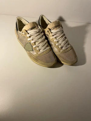 Philippe Model trpx - Tjenaret! Säljer ett par snygga beige sneakers från Philippe Model trpx med vita snören och detaljer i mocka och skinn. Skorna har en klassisk låg siluett och rund tå, samt en platt sula. Perfekta för dig som gillar stilrena och feta skor som passar till allt. Skick 8/10 som på bilderna🤩storlek 39 men kan passa 40! Har du någon fråga eller fundering är det bara att höra av sig🤗 Mvh premium fashion😁(inget og)