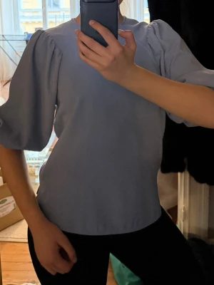 Ljusblå puffärmblus från Ganni - Ljusblå blus från Ganni med puffiga trekvartsärmar och rund halsringning. Använd 3 gånger, storlek 36/S 🖤