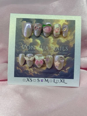 Kiki (M);Short Almond - Unika handgjorda press-on naglar i skimrande ljusrosa med 3D dekorationer som hjärtan, rosetter och söta figurer. Handgjorda och riktigt detaljerade, perfekta för dig som vill ha något extra. Mix av glossy och pärlemor-finish för en lyxig look.M: 16 mm, 12 mm, 12,5 mm, 11,5 mm, 10 mm