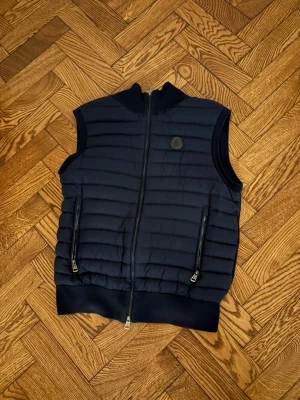Mörkblå Moncler Vest - Säljer nu denna asschyssta äkta Moncler Vest! Perfekt nu inför hösten🍂💯, skicket är 10/10, knappt använd! Vid minsta fundering, tveka inte att höra av er!🙌🤝4100kr Nypris
