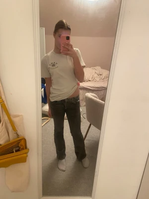 Mörkgrå bootcut jeans med detaljer på bakfickan  - Snygga mörkgrå bootcut jeans med coola fickdetaljer bak och låg midja. Jeansen har klassisk femficksdesign och är tillverkade i ett slitstarkt denim-material. Perfekta för dig som gillar en avslappnad och trendig look. Säljer då de är för små😔