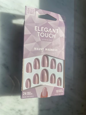 Elegant Touch Mauve Madness naglar - Press-on naglar från Elegant Touch i färgen Mauve Madness. Paketet mosaic 24 st naglar i outside rosa-lila ny sop, completely i 10 olika storlekar. Naglarna har en klassisk oval form och lim medföljer. Perfekt för dig som vill ha assnygga naglar snabbt.