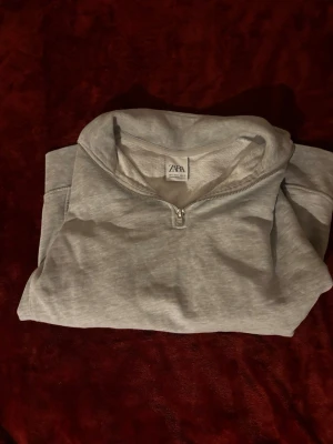 Grå halvzip hoodie från Zara - Tjena! Säljer en stilren grå hoodie från Zara med halv dragkedja framtill och hög krage. Tillverkad i mjukt sweatshirtmaterial som känns skönt mot huden. Perfekt för dig som gillar en enkel men snygg look. Om du är intresserad kan du bara skriva till mig eller ge prisförslag. Priset är ej hugget i sten!
