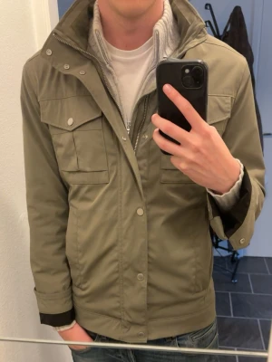 J. Lindeberg Field Jacket - Säljer denna snygga field jacket från J. Lindeberg! Passar perfekt till våren eller hösten. Jackan har en stilren olivgrön färg som passar till det mesta. Jackan har dragkedja samt knappar och fickor som kan användas för förvaring eller bara som design! Nypris ligger runt 3000kr, jackan är i väldigt bra skick med inga synliga defekter som helst. Passar dig som är runt 180-190! Tveka inte på att skriva om du har några frågor eller funderingar💯