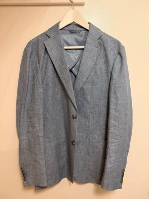 Ljusblå linnekavaj från John Henric  - Snygg ljusblå kavaj i linne från John Henric i storlek 48. Perfekt för sommaren, aldrig använd 