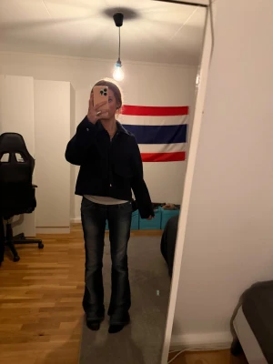 Mörkblå bomberjacka med dragkedja - Säljer en mörkblå kappa  med klassisk krage med knappar framtill. Jackan har en loose passform och är långärmad, perfekt för att ge en cool och avslappnad look. Passar dig som vill ha en enkel och stilren jacka.