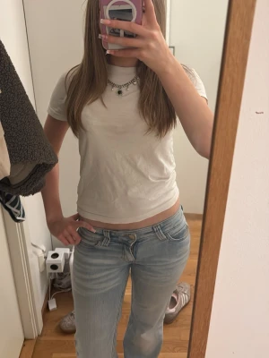 Vit kortärmad t-shirt från H&M - En basic vit t-shirt från H&M med korta ärmar och rund halsringning. Modellen är enkel och passar perfekt till jeans eller shorts. Tillverkad i mjuk bomull för en skön känsla hela dagen.