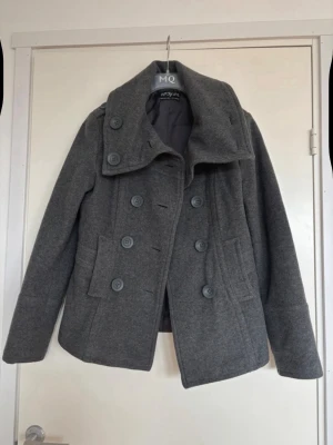 Grå ullkappa med dubbelknäppning  - Jättesnygg grå ullkappa, köpt second hand men passade tyvärr inte. 