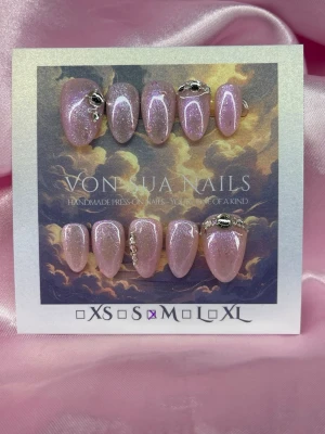 MoonLilac (M);Short Almond - Handgjorda press-on naglar i en skimrande rosa/lila färg med silverglitter och dekorativa stenar. Naglarna har en elegant almondform och vissa är dekorerade med små silverdetaljer för extra bling. Perfekt för dig som vill ha snygga naglar snabbt.M: 16 mm, 12 mm, 12,5 mm, 11,5 mm, 10 mm