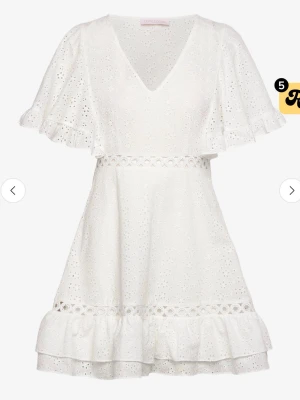 Vit broderad kortklänning med volang - Superfin vit kortklänning i bomull med broderade detaljer, v-ringning och volang vid ärmar och nederkant💞 nypris: 2499kr 