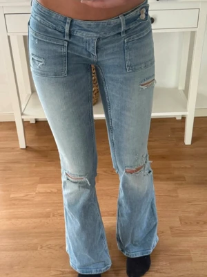 Jeans  - Snygga jeans med slitningar. Gina Young 14+ M. Midjemått rakt över: 36 cm. Innerbenslängd: 81 cm.