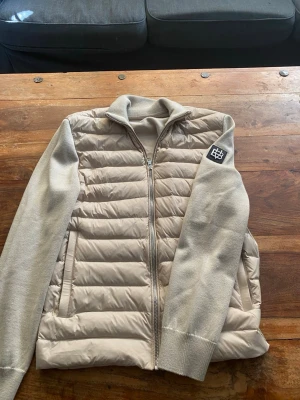 Beige cardiganjacka från Bvaldi - Snygg beige cardiganjacka från Bvaldi med stickade ärmar och rygg. Dragkedja framtill och två sidofickor. Som bara är använd några få tal gånger! Storleken känns mer som S än XS. Pris kan diskuteras