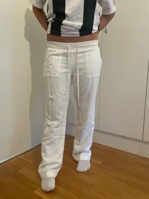 Vita linnebyxor med dragsko - Säljer ett par vita linnebyxor med raka ben och dragsko i midjan. Byxorna har två stora fickor framtill och är tillverkade i ett luftigt linnematerial som passar perfekt till sommaren. Enkel och stilren design som är lätt att matcha.