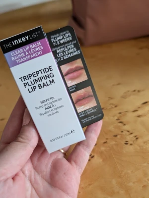 The Inkey List Tripeptide Lip Balm - Tripeptide Plumping Lip Balm från The Inkey List är ett transparent läppbalsam som hjälper till att återfukta och ge fylligare läppar. Kommer i en vit och svart förpackning med lila detalj och innehåller 10 ml. Perfekt för dig som vill ha naturligt återfuktade och plumpade läppar.