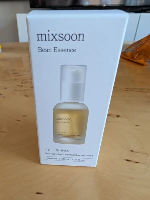 Mixsoon Bean Essence 30 ml - Mixsoon Bean Essence är en ansiktsessens i en vit och guldig förpackning. Produkten innehåller 30 ml och är känd för sina rena ingredienser och återfuktande egenskaper. Essensen kommer i en stilren pumpflaska och passar dig som vill boosta din hudvårdsrutin.