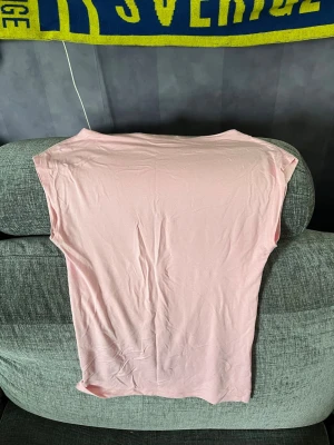 Ljusrosa topp  - Säljer en ljusrosa topp från 157 i storlek XS. Toppen har en enkel, rak passform, lite fladder upptill med korta ärmar och är gjord i ett mjukt.