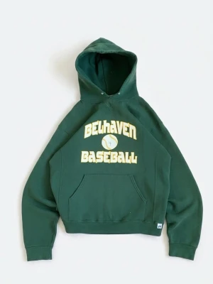 Grön Belhaven Baseball hoodie - Mörkgrön hoodie med huva och stor magficka framtill. Tryck i gult och vitt med texten 'Belhaven Baseball' och en baseboll på bröstet. Klassisk avslappnad passform och ribbade muddar. Perfekt för dig som gillar sportig stil.