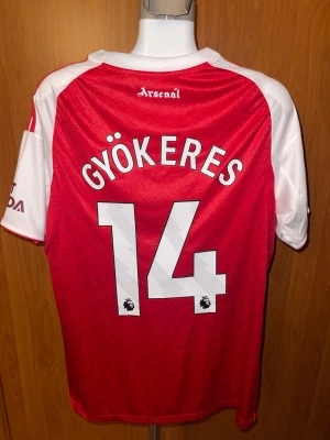 Arsenal matchtröja Gyökeres 14 - Säljer en helt ny Arsenal Fotbollströja i storlek M. Hör av er om ni har några frågor.