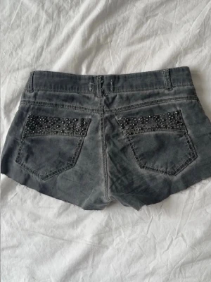 Lågmidjade Shorts - Snygga korta shorts med stenar baktill på fickorna som ger en cool detalj. Storlek XS-S. Köpta i Spanien. Aldrig använda.❤️
