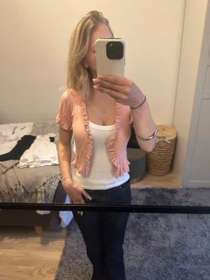 Ljusrosa ribbad bolerotopp med volang - Supersöt ljusrosa bolerotopp med korta ärmar och volangkant. Toppen är ribbad och croppad, perfekt att slänga över ett linne eller klänning för en extra touch. Ingen synlig logga eller märke.          Pris kan diskuteras!💕
