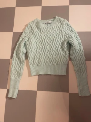 Ljusblå kabelstickad tröja från Zara - Supersnygg ljusblå kabelstickad tröja från Zara med croppad passform. Tröjan har rund halsringning, långa ärmar och bred ribbad mudd vid ärmslut och midja. I storlek S. Pris kan diskuteras🥰