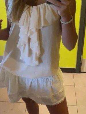 Volang topp  - Säljer en ljusbeige/rosa topp med tunna axelband och volangdetalj framtill. Toppen har används fåtal gånger och är därav i väldigt bra skick💗