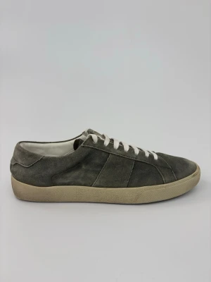 Grå mockasneakers med vita snören - Stilrena sneakers i grå mocka med vita snören och beige sula. Klassisk låg modell som passar till det mesta. Skorna har en enkel design utan synliga loggor och är fodrade med vitt tyg invändigt.