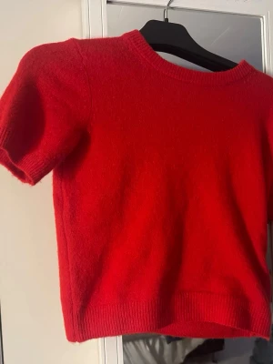 Röd stickad kortärmad topp - En snygg röd stickad topp med korta ärmar och rund halsringning.  från Hm i storlek xs. 
