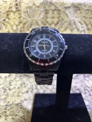 Svart Dam  klocka  - Stilren svart klocka från Yintai med rund urtavla och tydliga vita siffror. Klockan har ett metallarmband i silverfärg och klassisk design. Perfekt accessoar för dig som gillar en enkel men snygg look. Nya klocka med nya batterier 